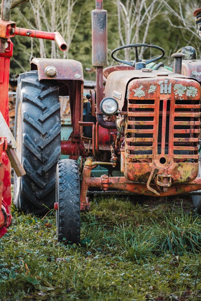 Close-up of an old rusty tractor on a rural farm, capturing decay and history.
